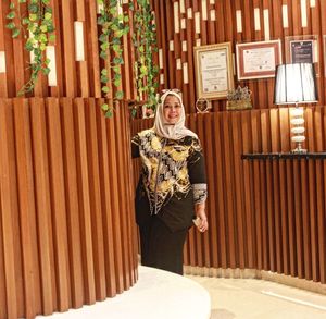 Portrait of woman standing against wall