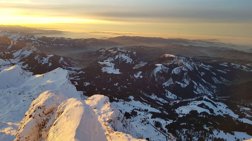 Scenic view of snowcapped mountains against sky during sunset