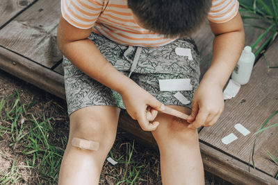 Child applies first-aid to knee scrape, brave steps taken towards healing, valuable of taking care