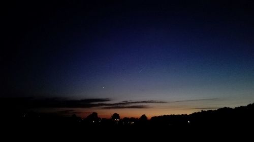 Silhouette landscape against sky at night