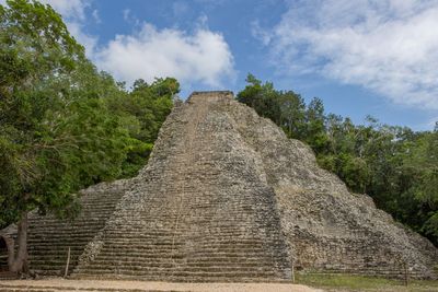 Stone structure against cloudy sky