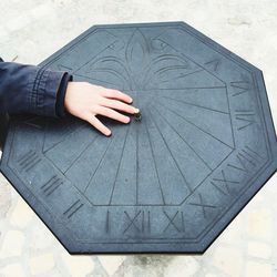 Cropped hand on sundial