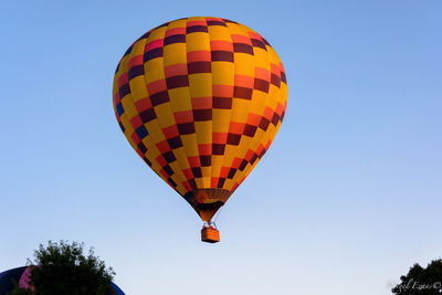 Low angle view of hot air balloon against clear blue sky