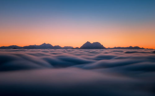 Scenic view of mountains against clear sky during sunset