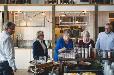 Senior male and female friends enjoying lunch buffet in restaurant