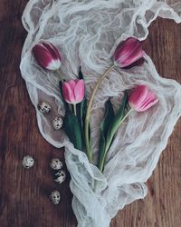 High angle view of tulips and quail eggs on table