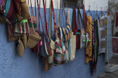 Close-up of clothes and bags hanging on market stall