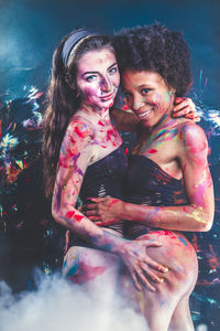 Young women wearing bikini while covered in body paint at nightclub