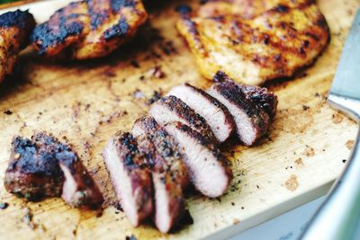 High angle view of roasted sliced meat on cutting board