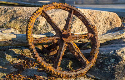 Close-up of rusty wheel on beach