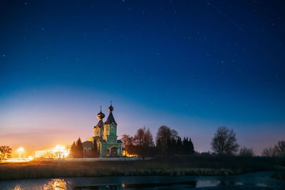 Illuminated building against blue sky at dusk