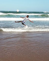 Man surfing in sea against sky