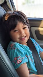 Portrait of cute girl sitting in car