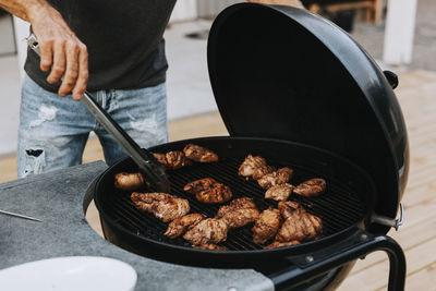 Man preparing meat on barbecue