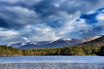 Scenic view of lake by mountains against sky