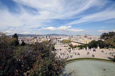 High angle view of city buildings against cloudy sky. exposició de montjuïc de barcelona