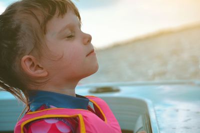 Close-up portrait of girl looking at the lake