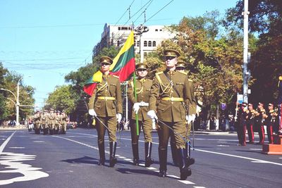 People walking on road against clear sky