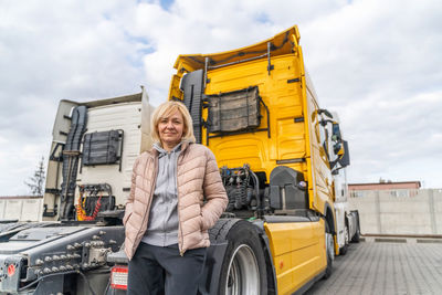 Portrait of smiling woman standing by truck