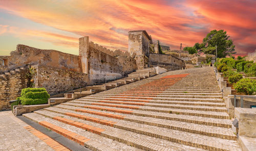 Buildings in city against sky during sunset