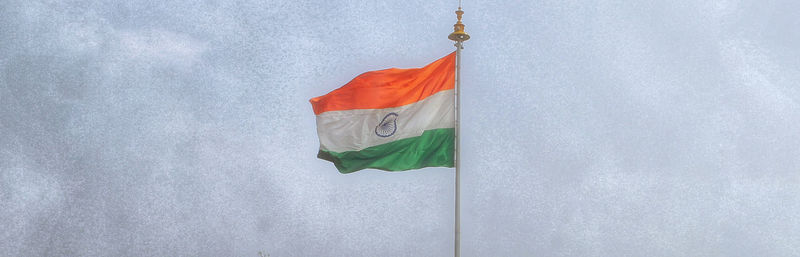 Low angle view of flag hanging against white wall