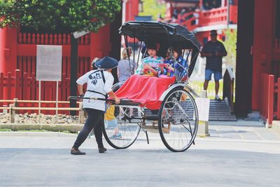 Woman pulling cart in city