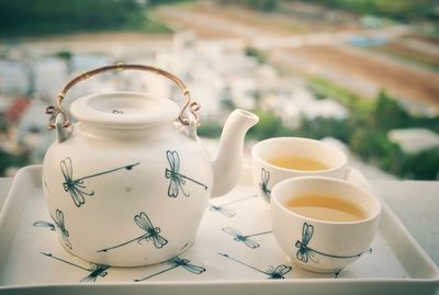 Close-up of tea cups and pot in tray