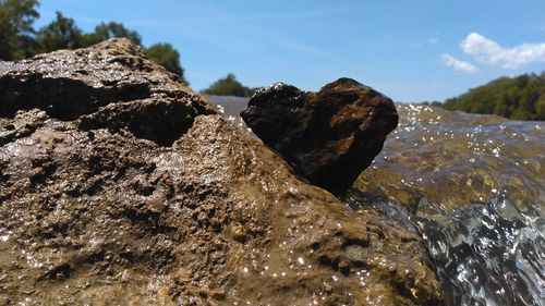 Close-up of rocks in water against sky