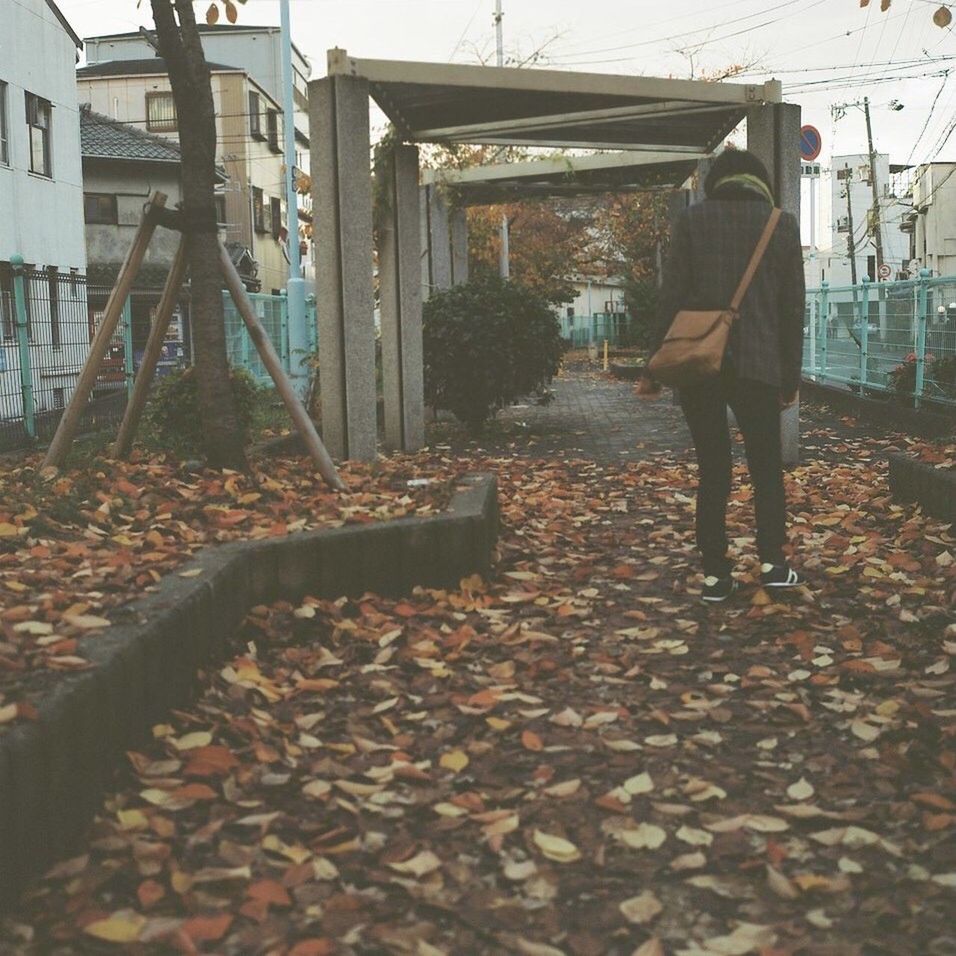 REAR VIEW OF PEOPLE WALKING ON STREET