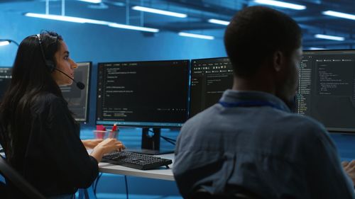 Rear view of man using laptop at office