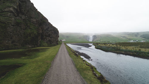 Road amidst green mountains against sky