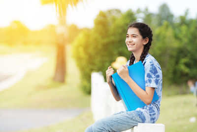 Portrait of smiling young woman sitting outdoors