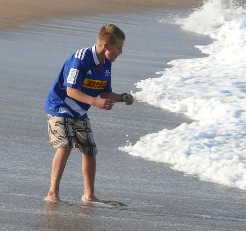 lifestyles, full length, leisure activity, water, casual clothing, sea, standing, beach, childhood, person, boys, vacations, day, elementary age, young men, motion, shore, fun