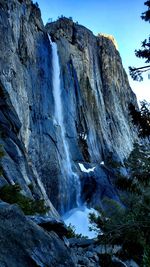 Low angle view of waterfall on rocks