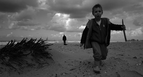 Boys standing on beach against sea