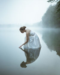 Rear view of man standing on lake