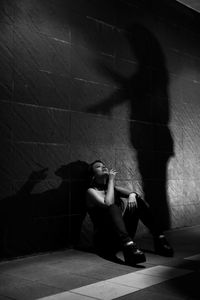 Young woman smoking while sitting on floor