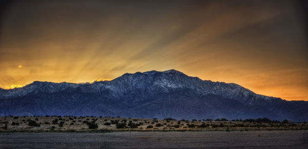 Scenic view of snowcapped mountains against sky during sunset