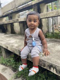 Portrait of boy sitting on bench