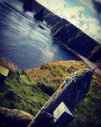High angle view of grass by sea against sky