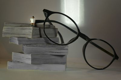 Close-up of books on table against wall