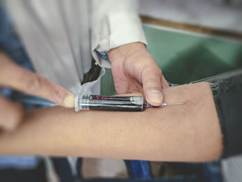 Close-up of man working in pen