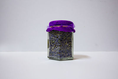 Close-up of purple flower on table against white background