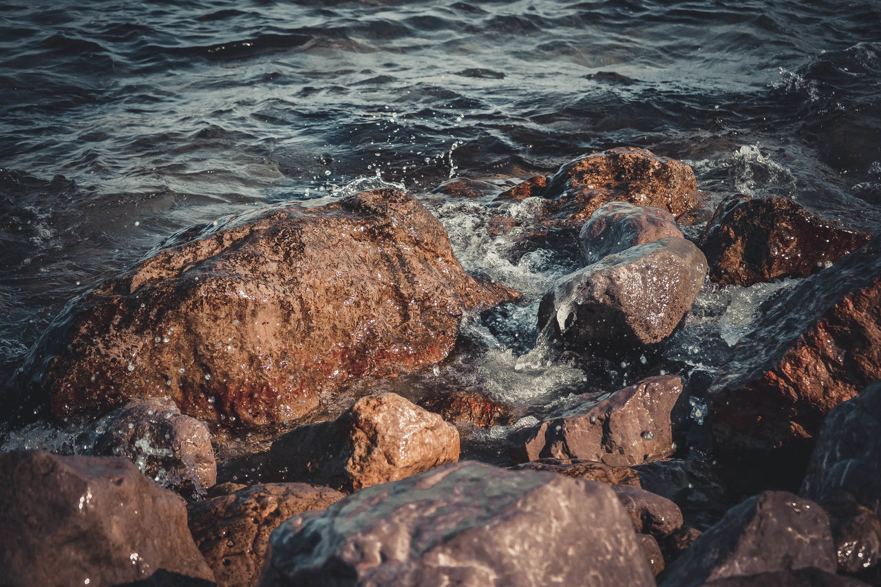 HIGH ANGLE VIEW OF ROCKS ON SHORE