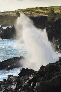 View of waves breaking on rocks