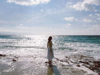 Full length of man standing on beach against sky