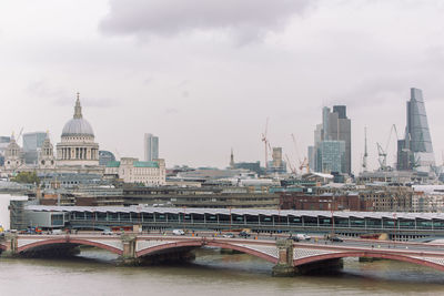 Bridge over river with city in background