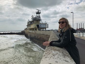 Portrait of woman at pier against sky