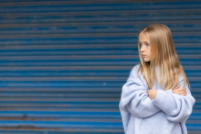 Young woman standing against wall