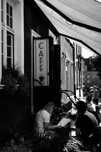 People sitting on street against buildings in city